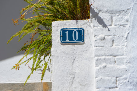 A closeup of a street number on a white wall.の写真素材