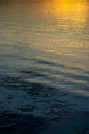 The sunbeams reflected in the beautiful clean water of Flores island in Indonesia during the sunsetの写真素材