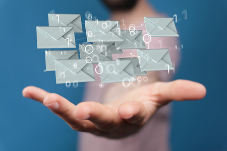 A 3D rendering of floating email icons on a man's hand - Concept of business communicationの写真素材