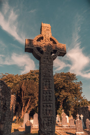 A cross on a grave against the blue sky in Irelandの写真素材