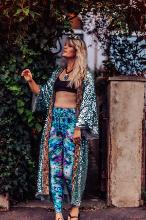 A gorgeous young blonde woman from the UK in vibrant activewear and a gown walking outsideの写真素材