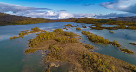 Aerial view of small islands on a lake and swamp, full of foliage colors, on a partly sunny, fall day, in Senja, Nordland, North Norwayの写真素材