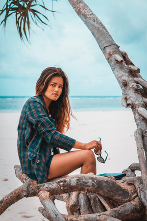 An attractive sexy Indonesian woman posing on the beach in Sulawesi, Togian Islands
