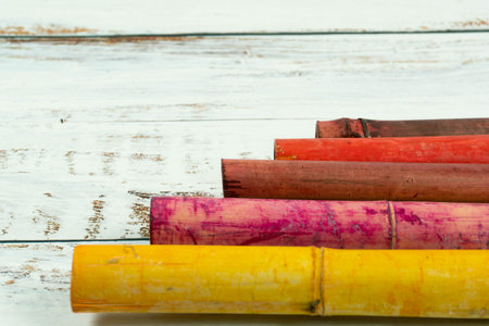 A shot of colorful bamboos on a white plank background