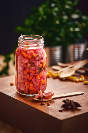 A closeup shot of putting pickles in a jar at a table in the kitchenの写真素材