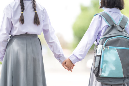 A closeup of kids holding hands outdoors with a blurry backgroundの写真素材