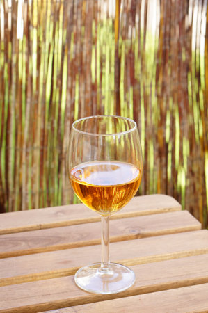 A glass of wine on a wooden tableの写真素材
