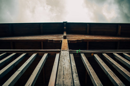 A low angle shot of a wooden hut with a terrace under the cloudy skyの写真素材