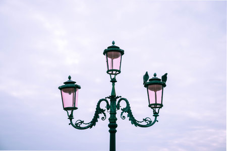 An antique lamppost against a cloudy skyの写真素材