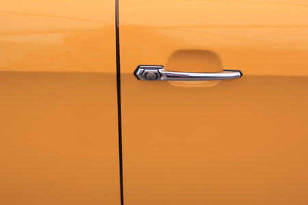 A closeup shot of a door of an orange vintage car