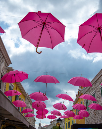 A low angle shot of pink umbrella decorations on a streetの写真素材