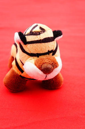 A closeup shot of a soft tiger toy on a pink backgroundの写真素材