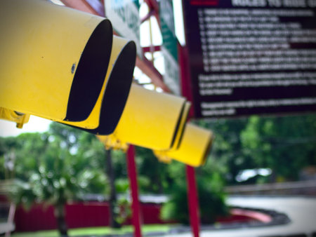An urban scenery of hanging yellow traffic lights in the street on a sunny day