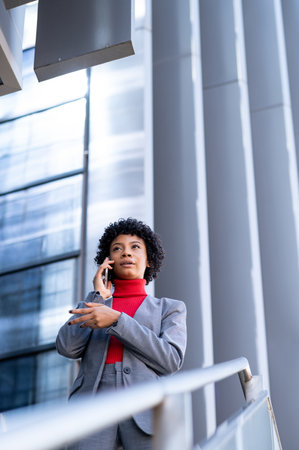 A young African-American businesswoman talking on the phone in a business building