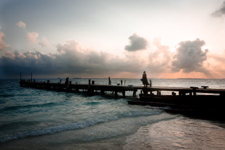 A female walking on a wooden pier on a gloomy dayの写真素材