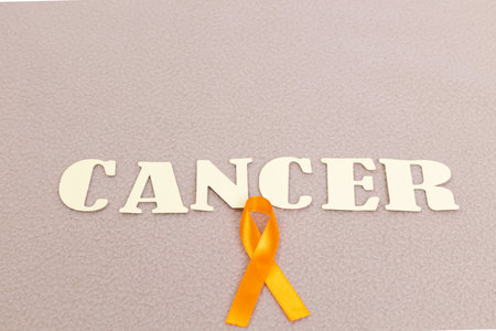 The letters spelling Cancer with the cancer symbol ribbon on pastel-colored fabric.の写真素材