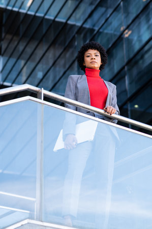 A young African-American businesswoman holding a laptop in a business buildingの写真素材