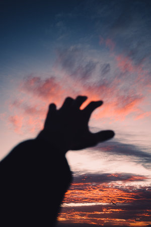 An image of human hand raised towards the sky.の写真素材