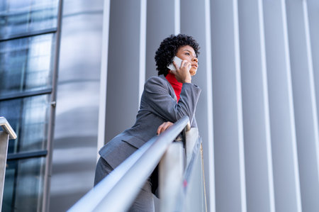 A young African-American businesswoman talking on the phone in a business buildingの写真素材