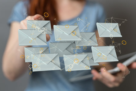 A 3D rendering of a woman pointing at floating email icons - Concept of business communicationの写真素材