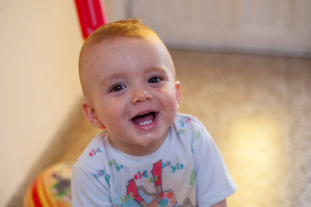 A portrait of a cute little Caucasian kid indoors with wet mouth.の写真素材