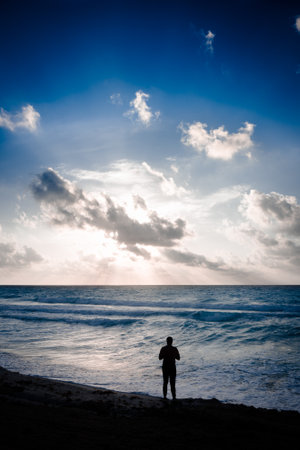 A silhouette of a man on the beach on the sunriseの写真素材