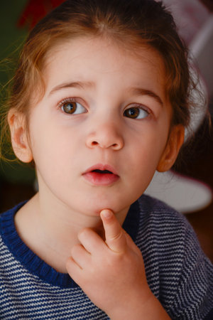 The picture shows a portrait of a little Caucasian girl with thoughtful expression