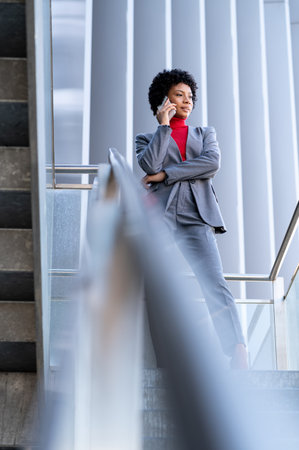 A young African-American businesswoman talking on the phone in a business buildingの写真素材