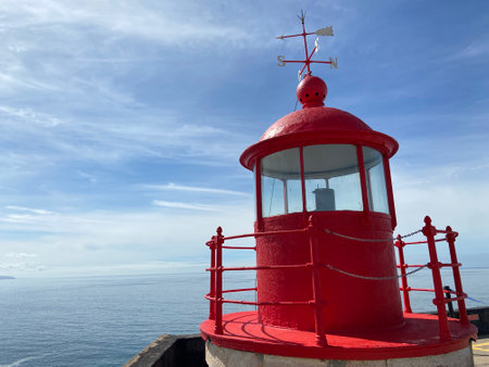 The view of the lighthouse against the background of blue sky. North Beach, Nazare, Portugal.の写真素材