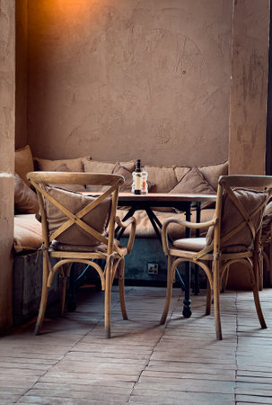 The vertical shot of the two wooden chairs and a sofa by a table insideの写真素材