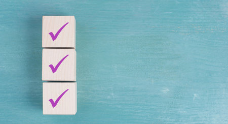 Three wooden cubes with purple checkmarks, blue background, copy space for text