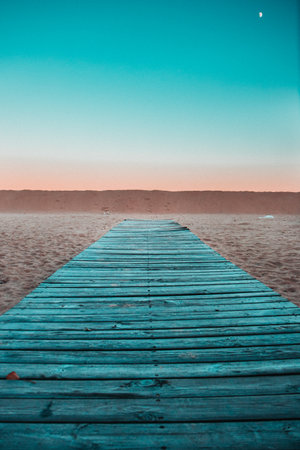 A vertical shot of a wooden way on the sunset sky backgroundの写真素材