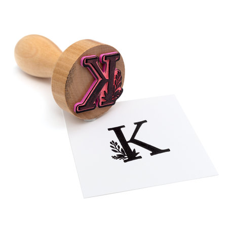 A closeup shot of a K calligraphy stamp on a white backgroundの写真素材