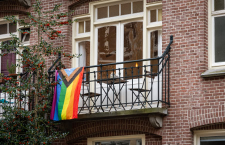 Progress Pride flag on a balcony of a building in Amsterdam, The Netherlands