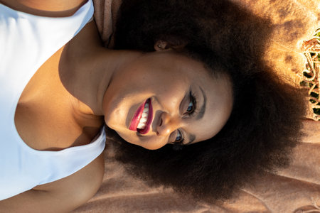 An African American female happily laying down the field of Tormes River in Salamanca City, Spain