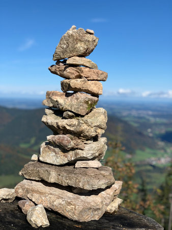 A vertical shot of a stack of rocks against a valley view