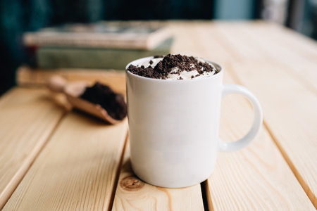 A closeup shot of coffee frappe topped with crushed cookies in a white cup