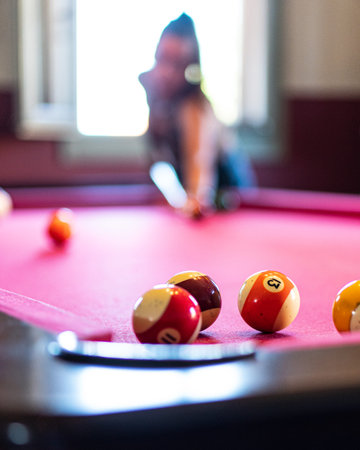 A close-up shot of billiard balls on the table with a blurred background of a girlの写真素材