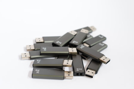Many black USB sticks with white background. Production of flash drives for data storage.の写真素材