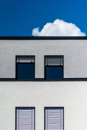 A vertical shot of a modern gray building with windows on a sunny day