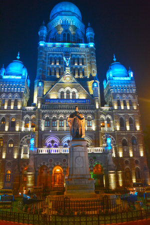 A vertical shot of the Brihan Municipal Corporation Building and Statue of Sir Pherozshah Mehta illuminated at night in Mumbai, Indiaの写真素材