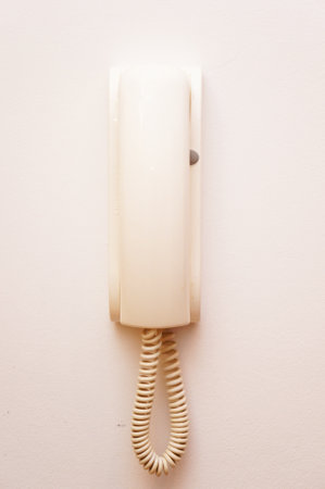 A vertical shot of an interphone handset intercom system