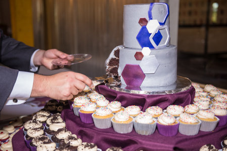 Two grooms cutting the wedding cake during their wedding ceremony