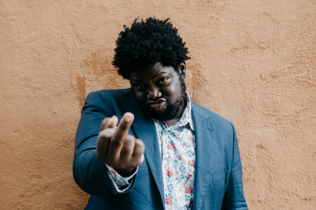 A shallow focus of a black man showing a middle finger