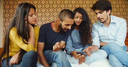A group of Indian friends watching something on a smartphone