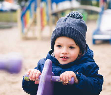 A portrait of a happy caucasian little boy on a playground