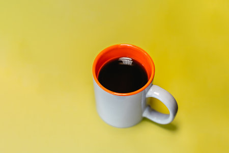 A mug of coffee on a yellow background