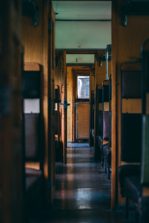 A vertical shallow focus of a narrow wooden corridor between seats in an old transport