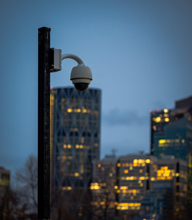 A surveillance camera on a post overseeing the activity in a private parking lotの写真素材