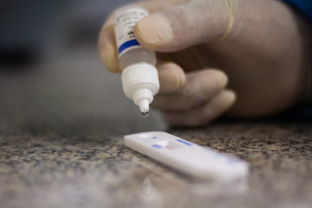 A closeup on a hand of a doctor applying chemical on a test sample for analysis